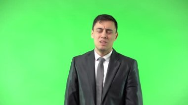 Siyah takım elbiseli adam elleri bağlı yalvarıyor.