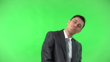 Takım elbiseli gülen adam akıllı telefondan selfie çekiyor.