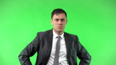 Şık giyinmiş, kendine güvenen ciddi bir işadamı kamerayı işaret ediyor.