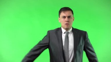 Takım elbiseli neşeli erkek stüdyoda selam veriyor.