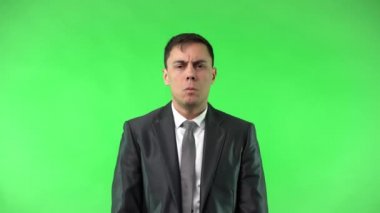 Şok olmuş takım elbiseli adam kameraya bakıyor.