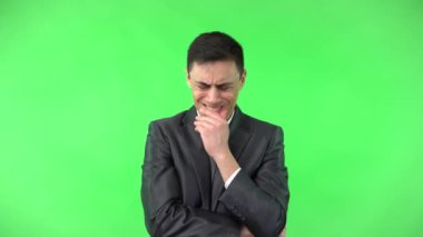 Odaklanmış endişeli adam çeneye dokunuyor ve düşünüyor.