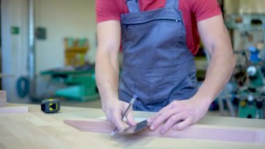 Tanınmayan marangoz hafif atölyede notlar alıyor.