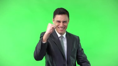 Başarılı genç, zarif bir adam yumruk hareketi yapıyor ve gülümsüyor.