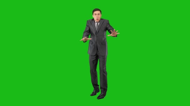 Een bange zakenman in een lichte studio. Groene achtergrond. — Stockvideo