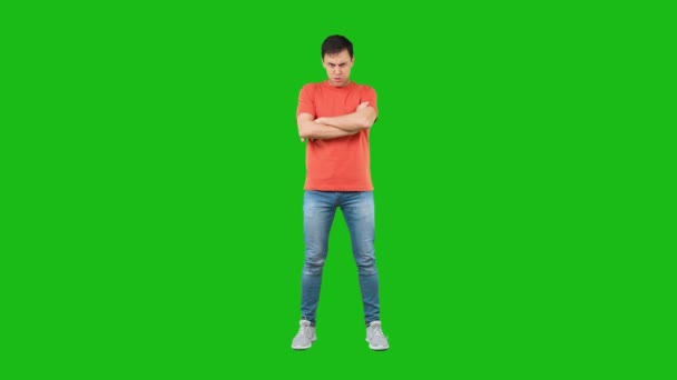 Θυμωμένος άντρας με σταυρωμένα χέρια. Πράσινο φόντο — Αρχείο Βίντεο