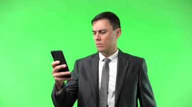 Ciddi bir adam akıllı telefondan kötü haberler okuyor ve kafası karışık.