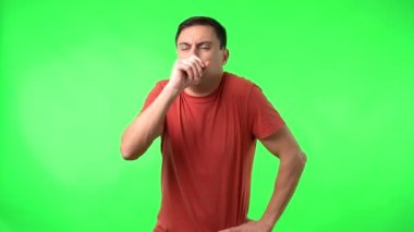 Adam öksürüyor ve tıbbi maske takıyor.