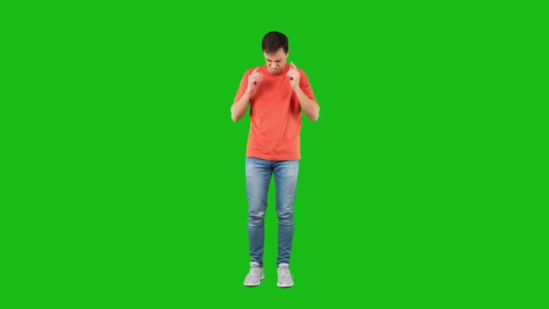 Unzufriedener Mann deckt Ohren vor Lärm ab. Grüner Hintergrund — Stockvideo