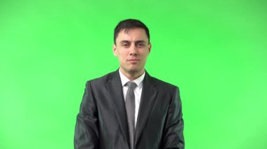 Elleri belinde, takım elbise içinde gülümseyen iyimser bir adam.