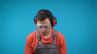 Gözlük ve kulaklık takan üzgün bir erkek marangoz.