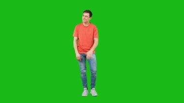 Pozitif genç adam işaret ediyor. Yeşil arkaplan