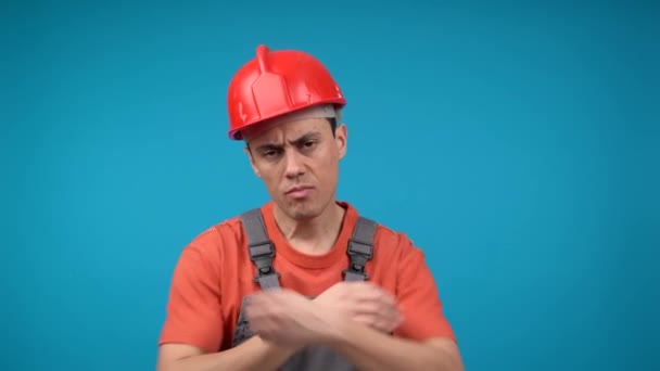 Uttråkad manlig byggare i uniform med korsade armar — Stockvideo