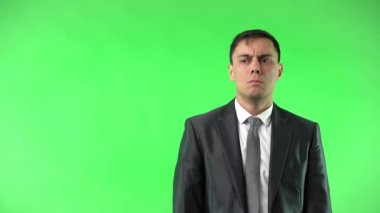 Takım elbiseli adamın stüdyoda yanaklarına dokunması hayret verici.