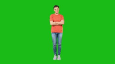 Cheerful man standing in studio. Green background