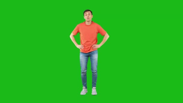 Amazed man covering mouth in studio. Green background — Vídeo de Stock