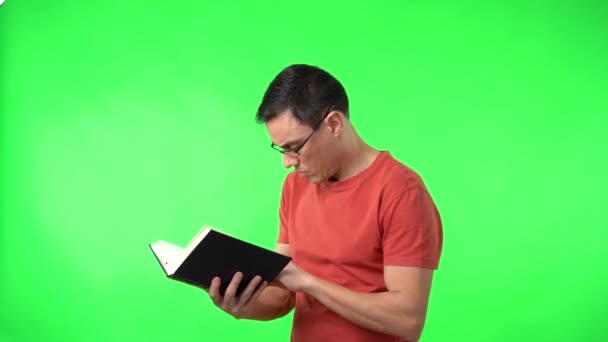 Clever man in eyeglasses and red t shirt reading book — Stockvideo