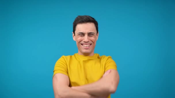 Cheerful man standing with crossed arms and laughing in studio — Stock Video