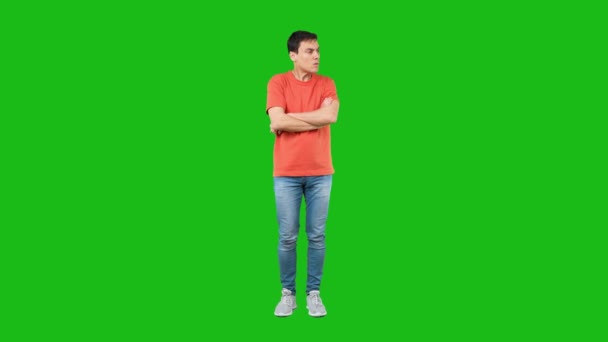 Angry male showing stop gesture and pouting lips in green studio — Video Stock