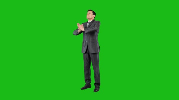Calm businessman meditating on chroma key, full body — Stock video