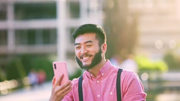Χαμογελώντας Κομψό Ασιατικό Άνθρωπος Κάνει Μια Βιντεοκλήση Κινητό Εξωτερικούς Χώρους — Αρχείο Βίντεο