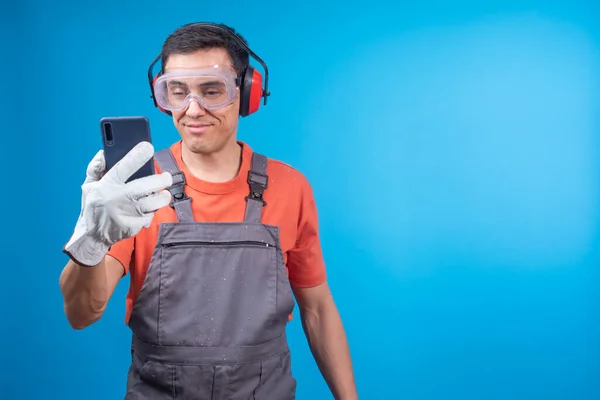 Glad Male Carpenter Workwear Protective Goggles Earmuffs Gloves Smiling Checking — Stock Photo, Image