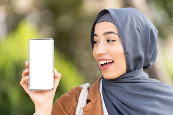 Muslimská Žena Ukazuje Obrazovku Mobilu Zároveň Usmívá Překvapeným Výrazem — Stock fotografie