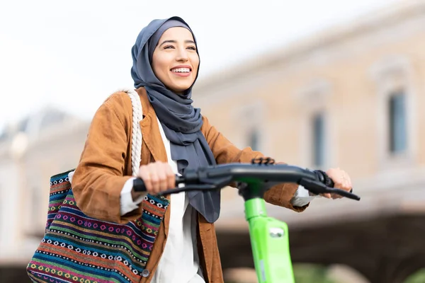 路上で電動スクーターに乗ってヒジャーブ州のイスラム教徒の女性の低角度ビュー — ストック写真