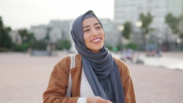 ムスリム女性は広場で笑っている彼女の頭の後ろにヒジャーブを身に着けています — ストック動画