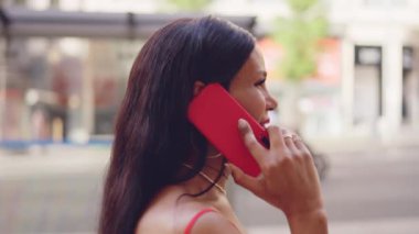 Profile of a smiling transgender woman talking to the mobile