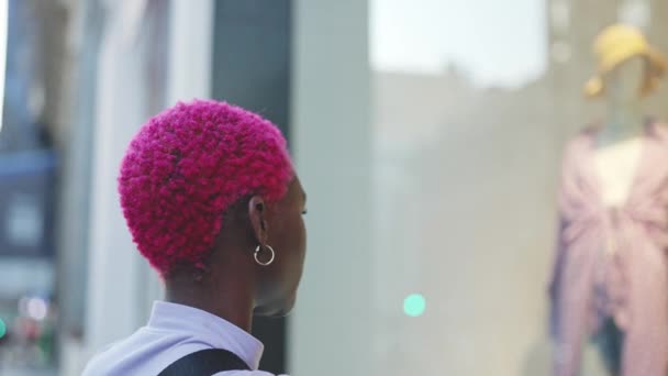 Afro Rövid Rózsaszín Hajjal Néz Egy Kirakatban Város Utcájáról — Stock videók