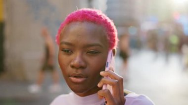 African young stylish woman talking to the mobile with an angry expression in the street