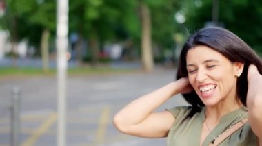 Two caucasian friends talking closely while smiling in the street