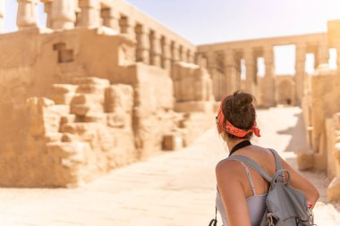 Luxor 'daki eski bir Mısır tapınağını küçümseyen bir kadının arka tarafına odaklan.