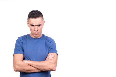 Kollarını beyaz bir arka planda kavuşturmuş öfkeli bir adamın stüdyo portresi.