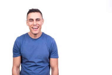 Kameraya bakan rahat bir ifadeyle gülümseyen bir adamın beyaz arka planlı stüdyo portresi.