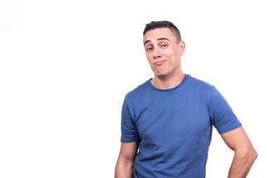 Kendini beğenmiş bir ifadeyle kameraya bakan bir adamın beyaz arkaplanlı stüdyo portresi