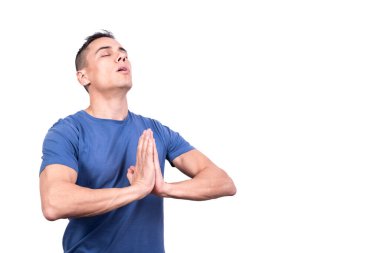 Gözleri kapalı beyaz bir arka planda dua eden bir adamın stüdyo portresi.