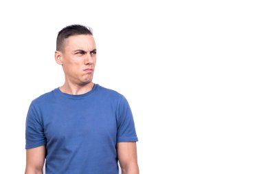 Şüpheli bir ifadeyle yana bakan bir adamın beyaz arka planlı stüdyo portresi.