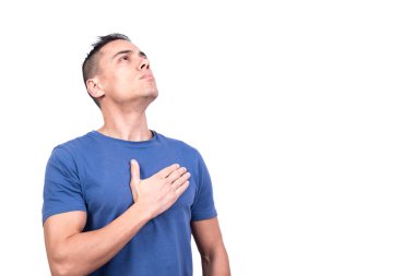 Elini kalbine koyup gururla yukarı bakan beyaz bir adamın stüdyo portresi.