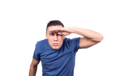 Stüdyo portresi, beyaz arka planda gözlerini ufka bakan ışıktan koruyan bir adam.