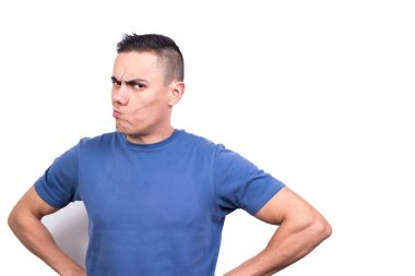 Elleri kalçasında ve şüpheli bir ifadeyle beyaz arka planda bir adamın stüdyo portresi.