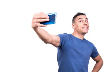 Cep telefonuyla selfie çeken bir adamın beyaz arka planlı stüdyo fotoğrafı.