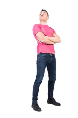 Kollarını kavuşturup beyaz arka planda kibirli bir yüz ifadesiyle dik dik bakan kibirli bir adam.