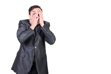 Siyah saçlı, yüzü resmi kıyafetli, korkmuş genç girişimci beyaz arka planda kameraya bakıyor.