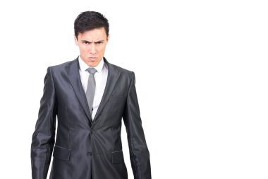 Siyah saçlı, resmi takım elbiseli ve kravatlı kızgın genç patron beyaz arka planda ciddi yüz ifadesi olan kameraya bakıyor.