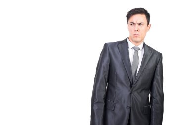 Beyaz arka planda duran ve şaşkın bakışlarla yüzünü çeviren resmi takım elbiseli güvenilmez erkek yönetici.