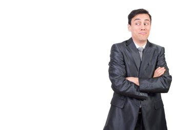 Resmi takım elbiseli, beyaz arka planda kolları çapraz duran ve stüdyoda izole bir şekilde duran afallamış bir erkek resmi.