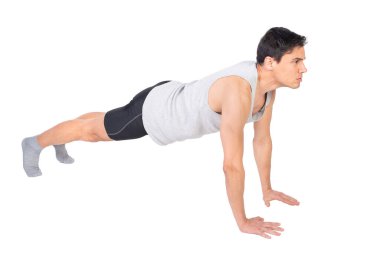 Spor giyimli, kaslı bir erkeğin yoğun idman sırasında beyaz arka planda izole edilmiş şınav çekerken tüm vücudu görünümü.