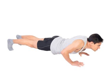Beyaz arka planda izole edilmiş fitness eğitimi sırasında spor yapan erkek vücudunu yere indiriyor.